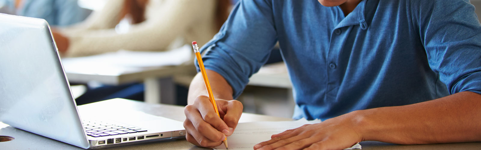 Photo of student with notes and computer