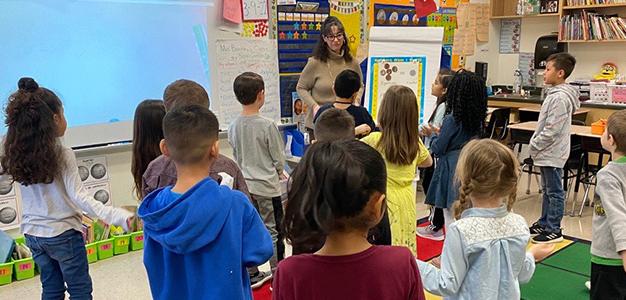 Teacher in classroom with boys and girls